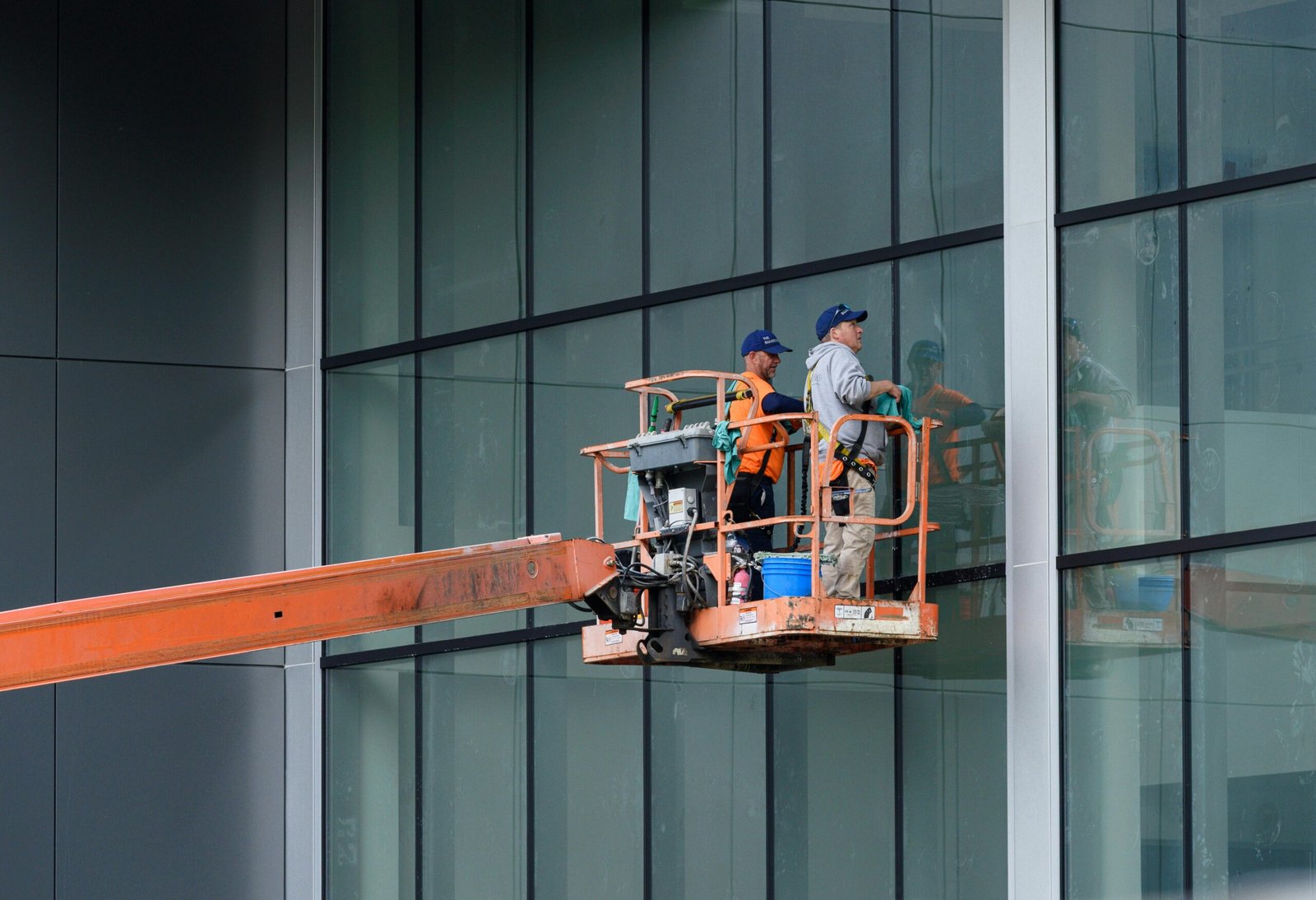 Home Two workers clean large glass windows using a cherry picker lift outside a building in Canonsburg, PA.